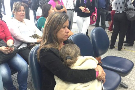 A advogada Daniele Alvarenga de Souza com a filha no colo espera por mais de cinco horas para receber alvarás de clientes