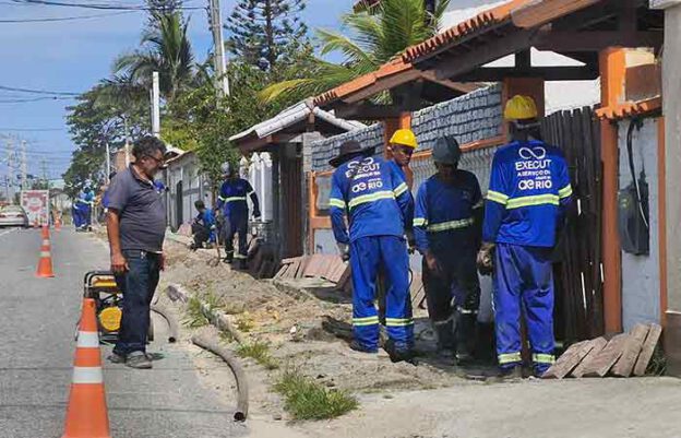 Operários cavam valas para instalar canos e hidrômetros em todas casas, como as da praia de Maricá