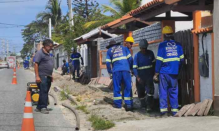 Operários cavam valas para instalar canos e hidrômetros em todas casas, como as da praia de Maricá